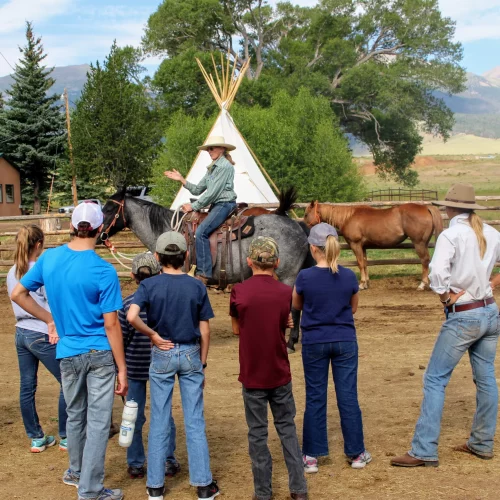 cowgirl instructing a group of people during a day at the ranch at music meadows