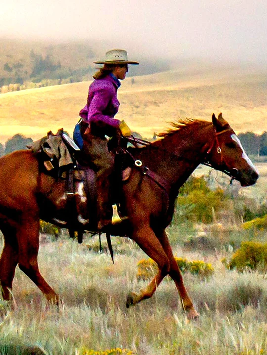 cowgirl riding a horse at Music Meadows Ranch